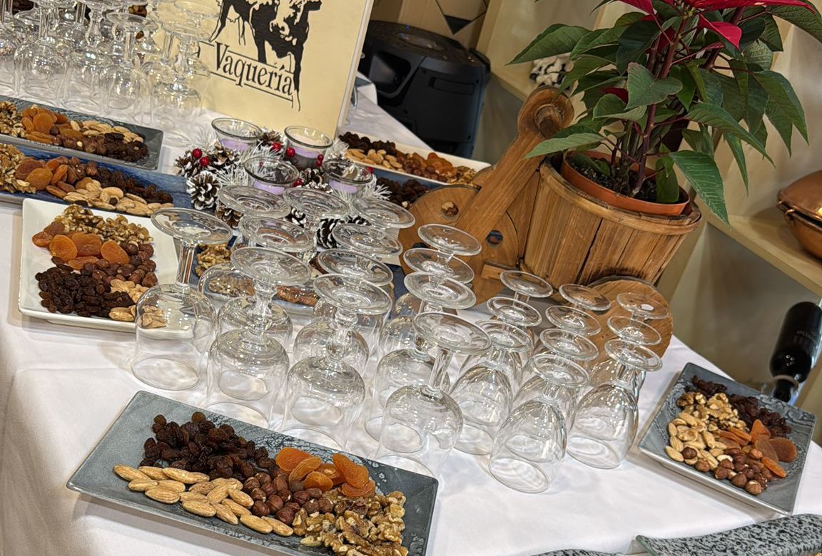 Mesa larga vestida con copas y aperitivos, montada para una celebraci&oacute;n de grupo en La Vaquer&iacute;a