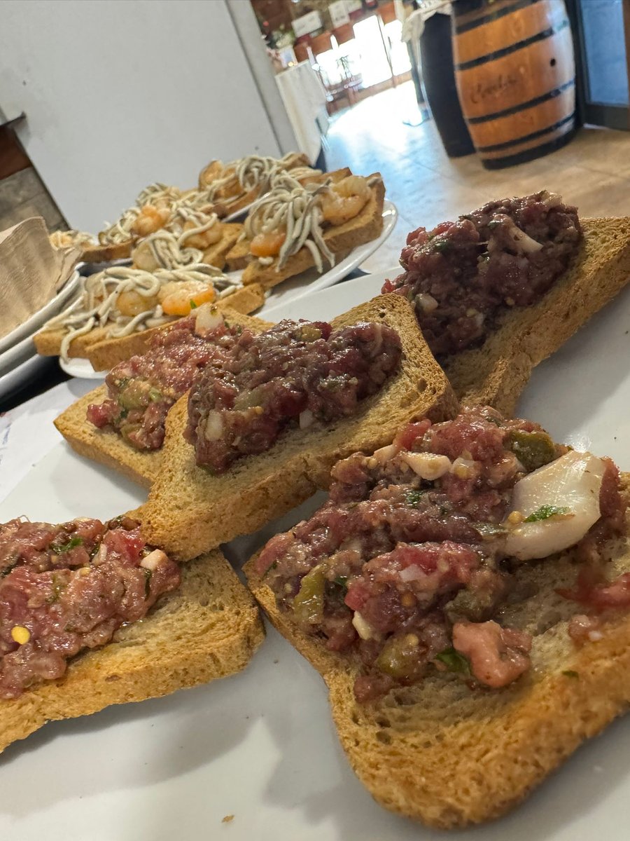 Tostas variadas para compartir en La Vaquería: steak tartar, anchoas y bacalao