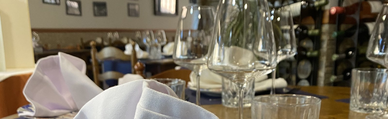 Mesa vestida en la sala de La Vaquería, con la bodega al fondo